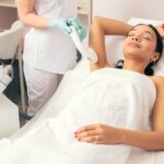 Frau liegt entspannt im Studio und erhält eine professionelle Laser-Haarentfernung unter den Achseln in Essen