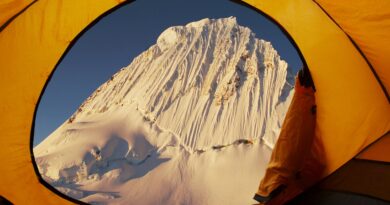 blick aus gelbem zelt auf schneebedeckten gipfel im winter bei campingtour mit petroleum heizung camping